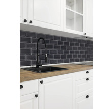 Küchenspüle mit Armatur, Arbeitsplatte und Fliesenrückwand in einer hellen Küche.