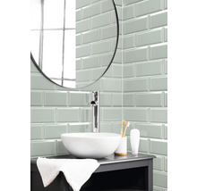 Badezimmer mit Waschbecken, Armatur und Wandfliesen im Metro-Stil.