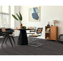 Esszimmer mit Tisch, Stühlen und dunklem Laminatboden.