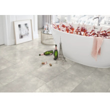 Heller Raum mit Badewanne gefüllt mit Getränkeflaschen, Fliesenboden, Eiffelturm-Dekoration und Bild an der Wand