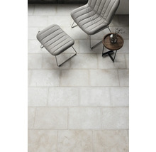 Fliesenboden im Innenraum mit Sessel und Beistelltisch.