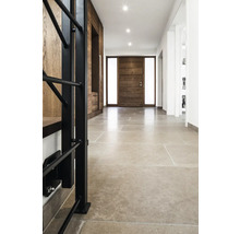 Flur mit Natursteinboden, Holztür und Garderobe