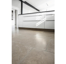 Küchenszene mit weißen Schränken und Bodenfliesen.