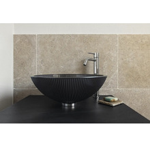 Auf einer Waschtischplatte steht ein Aufsatzwaschbecken mit Armatur und Seife.