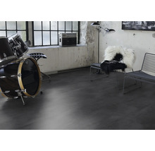 Wohnraum mit Schlagzeug, Stühlen und Musikanlage auf dunklem Bodenbelag