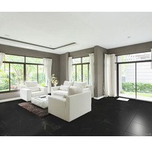 Wohnzimmer mit schwarzen Bodenfliesen, weißen Möbeln und großen Fenstern.