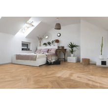 Helles Schlafzimmer mit Dachfenster, Bett und Parkettboden im Fischgrätmuster