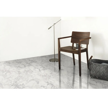 Heller Raum mit Bodenbelag in Marmoroptik, Stuhl, Stehlampe und Korb