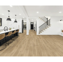 Heller Raum mit offener Küche, Treppe und Vinylboden in Holzoptik.