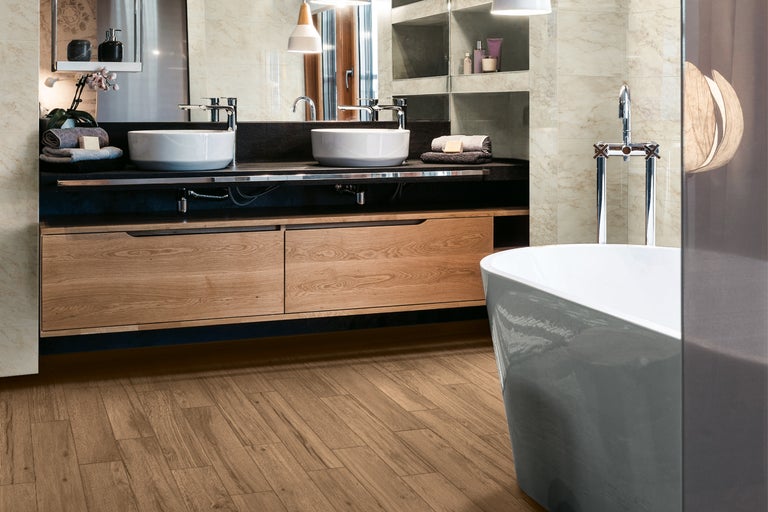 Badezimmer mit Doppelwaschbecken, Holzunterschrank, Badewanne und Fliesenboden in Holzoptik