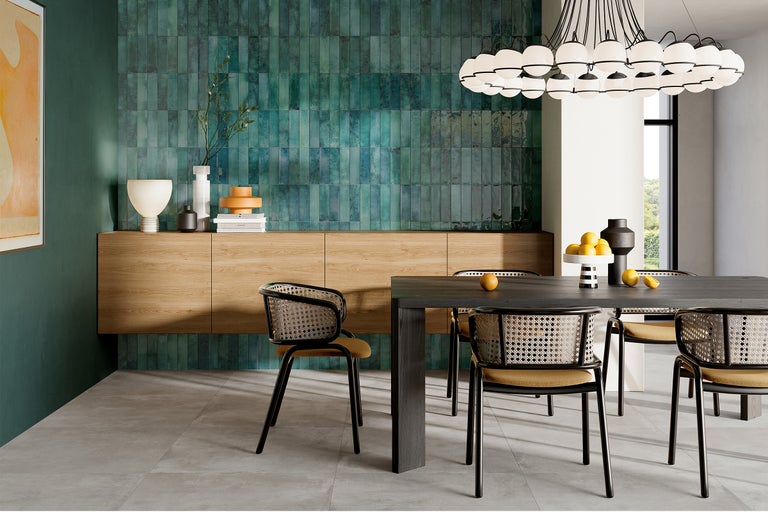 Modernes Esszimmer mit grünen Wandfliesen, Holzboden und Esstisch mit Stühlen.