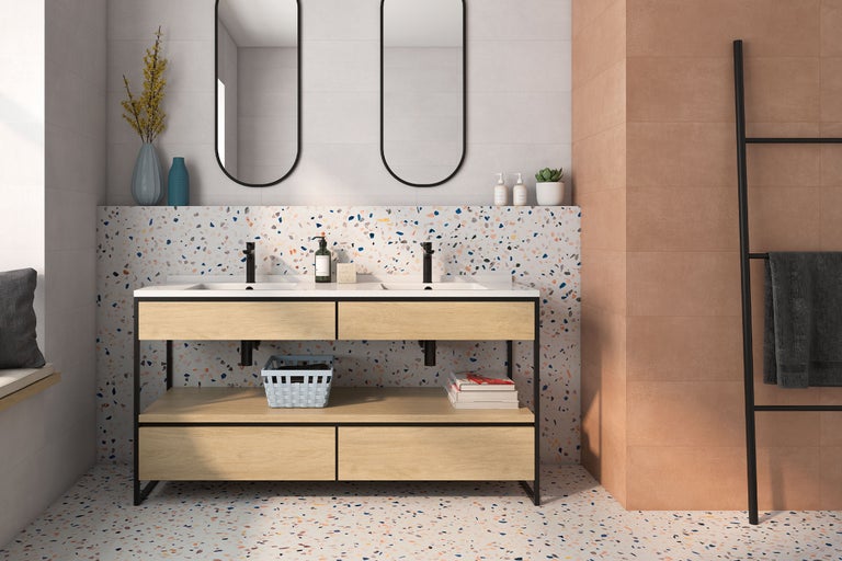 Modernes Badezimmer mit Doppelwaschtisch aus hellem Holz, Terrazzo-Fliesen an Boden und Wand, terracottafarbenen Wandfliesen und zwei ovalen Spiegeln.