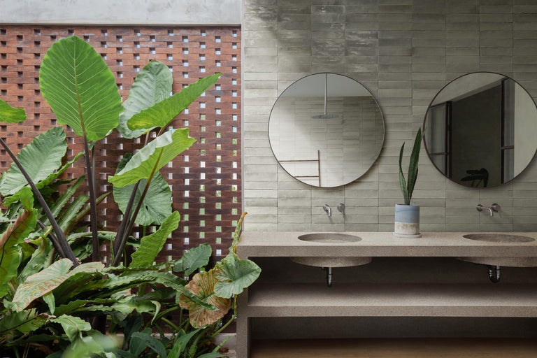 Badezimmer mit Waschtisch, Spiegeln, Pflanzen und Mauerwerk