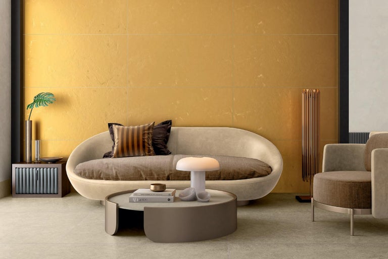 Wohnzimmer mit Sofa, Sessel, Tisch und Wandfliesen für ein modernes Ambiente