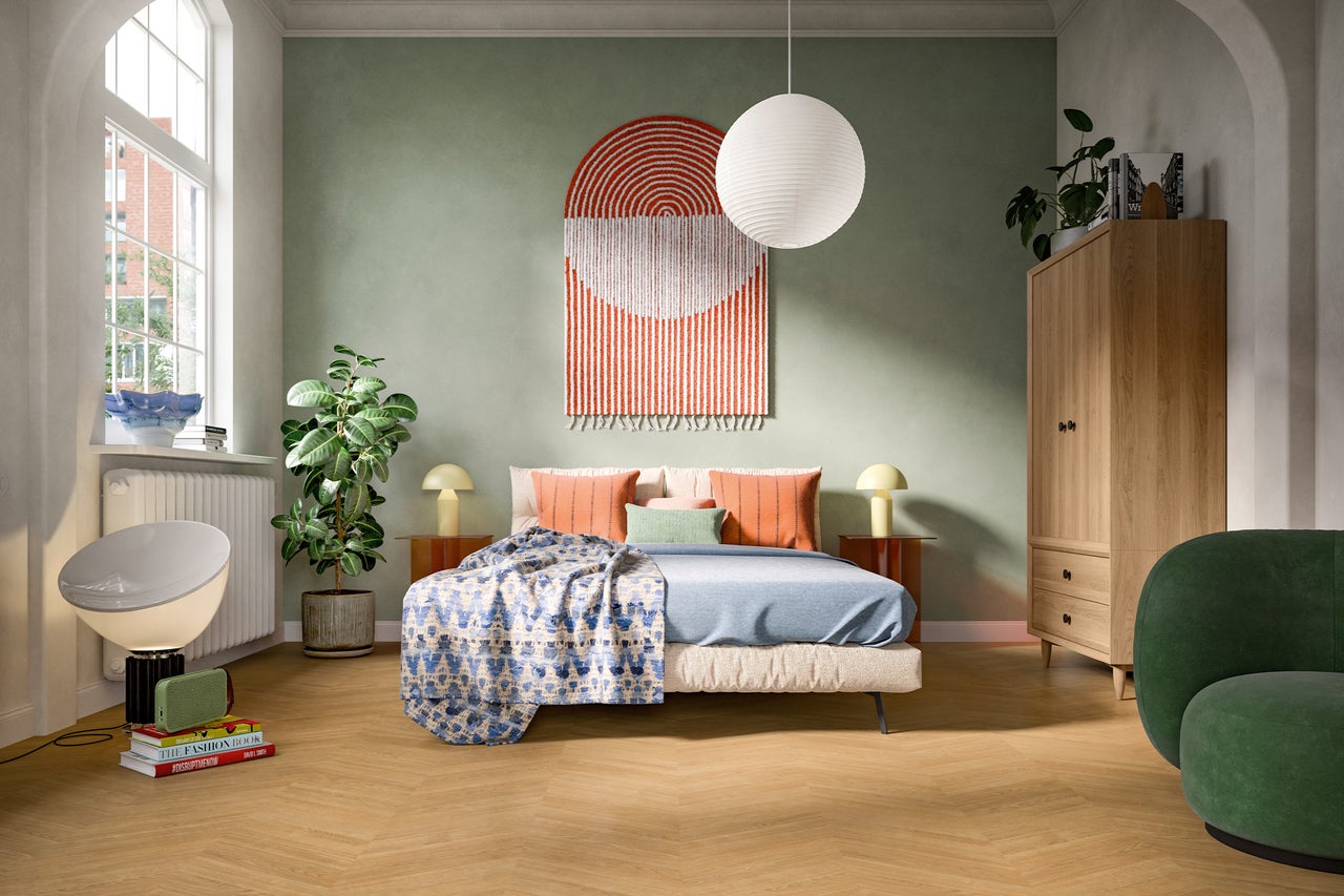 Schlafzimmer mit Bett, Nachttischen, Lampe, Schrank und Sessel
