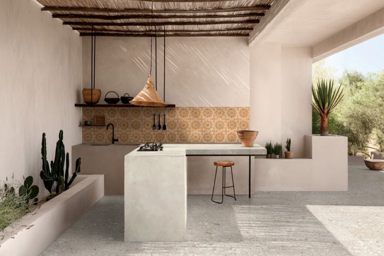 Helle Außenküche mit Kochinsel, Spüle, Fliesenrückwand und dekorativer Beleuchtung