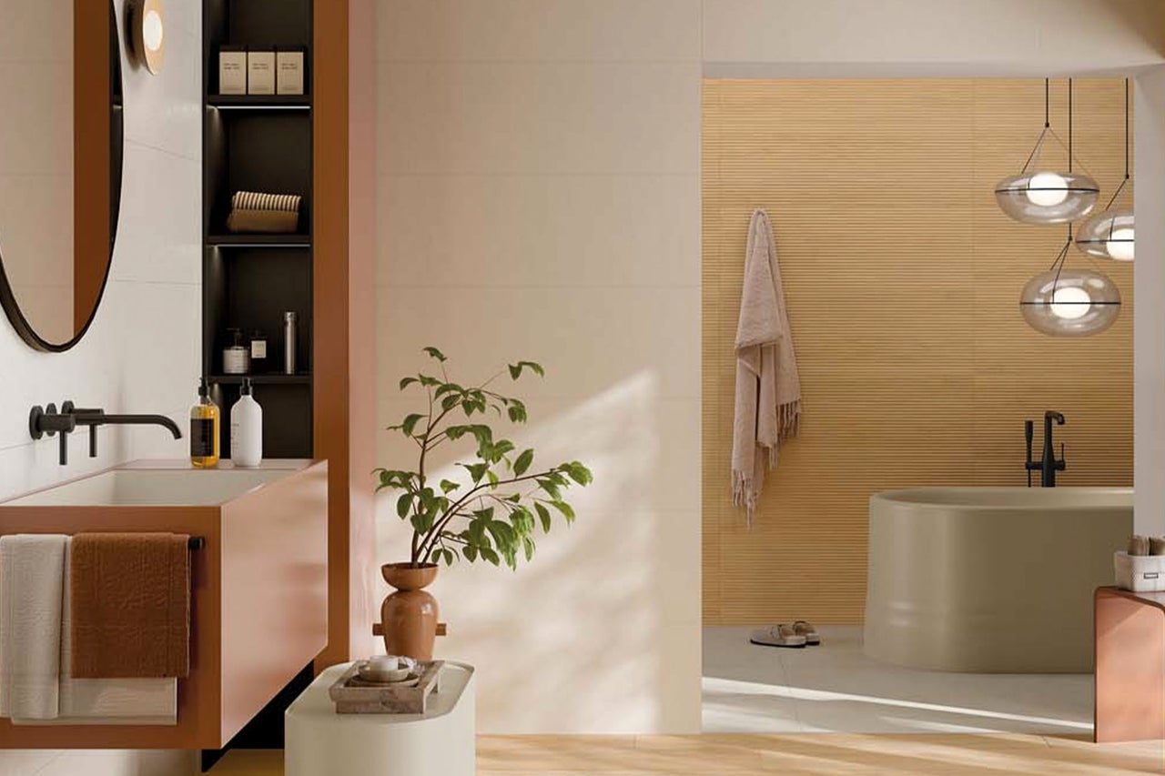 Modernes, helles Badezimmer mit freistehender Badewanne, Waschtisch, schwarzen Armaturen und Wandfliesen in Holzoptik.