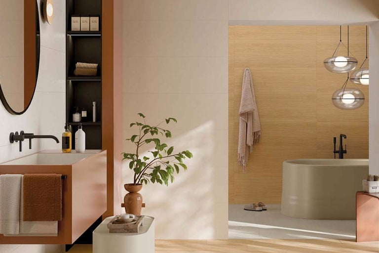 Modernes, helles Badezimmer mit freistehender Badewanne, Waschtisch, schwarzen Armaturen und Wandfliesen in Holzoptik.