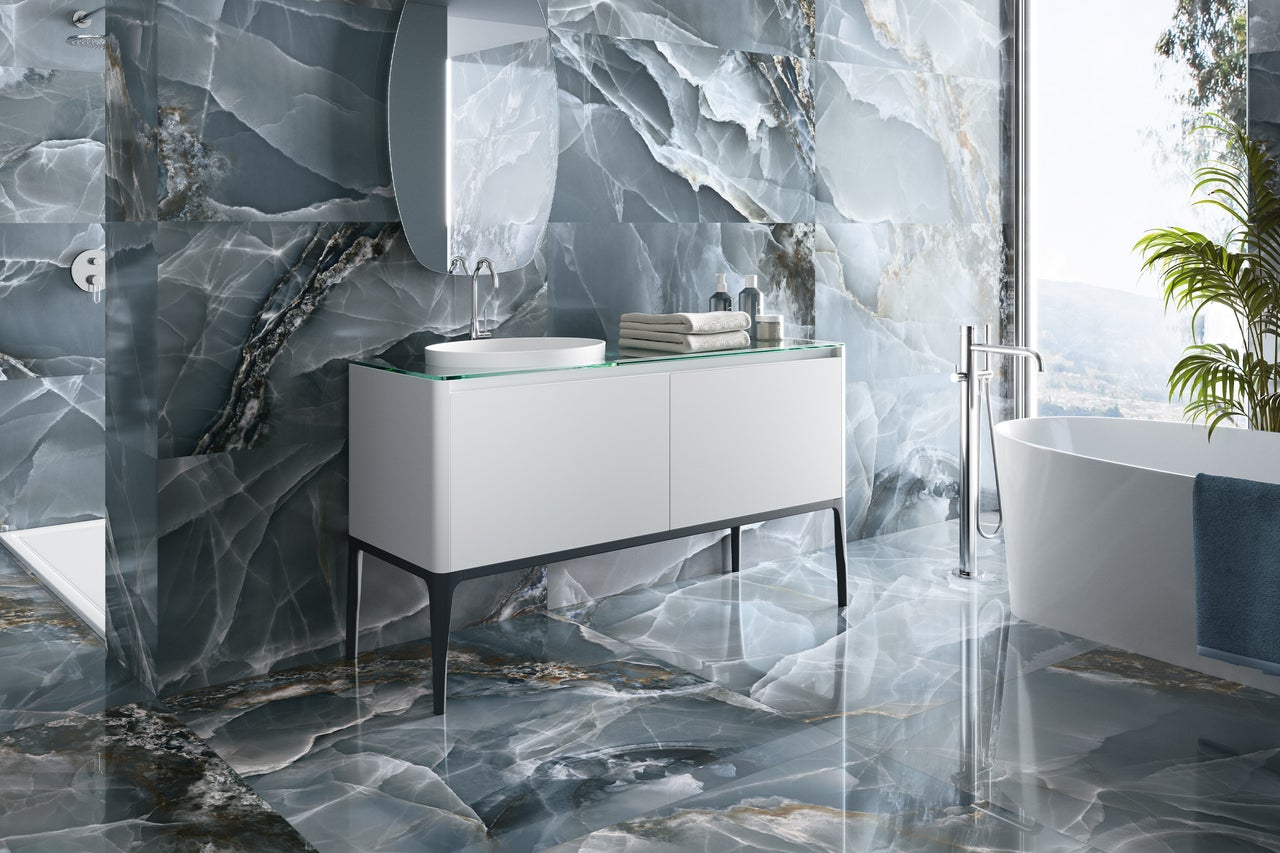 Helles Badezimmer mit Waschbecken, Spiegel, Badewanne und Fliesen in Marmoroptik