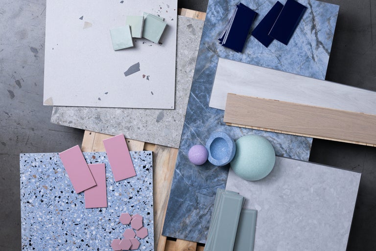 Eine Auswahl an Bodenfliesen, Wandfliesen und Dekorationselementen auf einer Holzpalette.