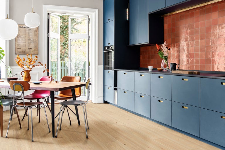 Helle Küche mit Holzboden, Esstisch und blauen Küchenschränken