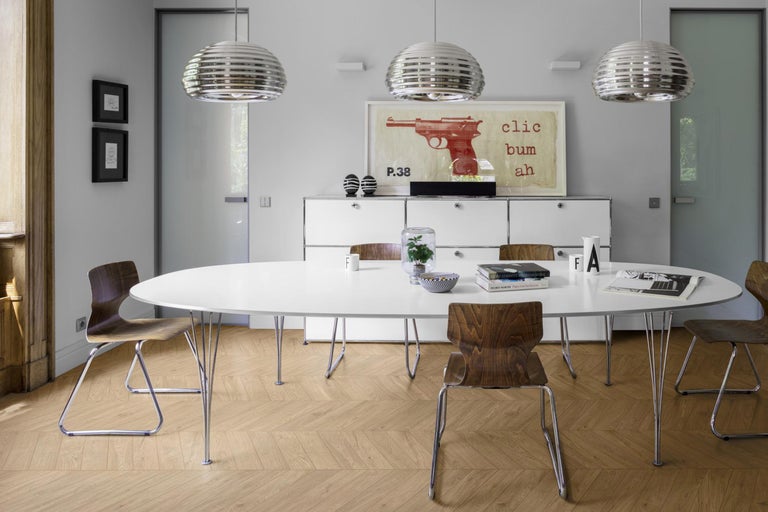 Esszimmer mit weißem Tisch, Holzstühlen und Pendelleuchten