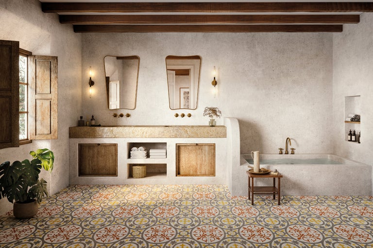 Badezimmer mit Waschtisch, Spiegeln, Badewanne und gemusterten Fliesen