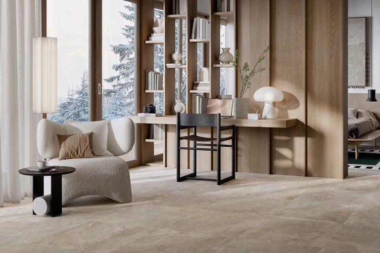 Helles Zimmer mit Sessel, Tisch und Arbeitsplatz vor dem Fenster