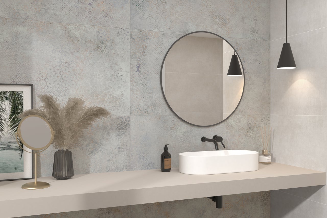 Modernes Badezimmer mit Waschtisch, rundem Spiegel und dekorativen Elementen.