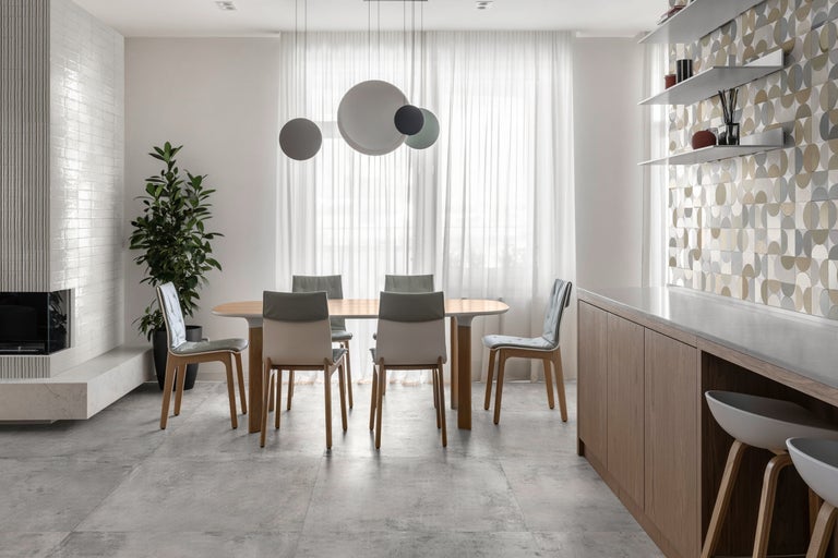 Heller Essbereich mit Esstisch, Stühlen, Beleuchtung und dekorativer Wandgestaltung