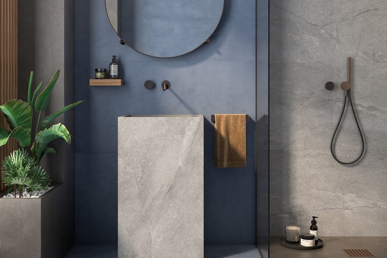 Modernes Badezimmer mit freistehendem Waschbecken, rundem Spiegel, Handtuch und Duscharmatur.