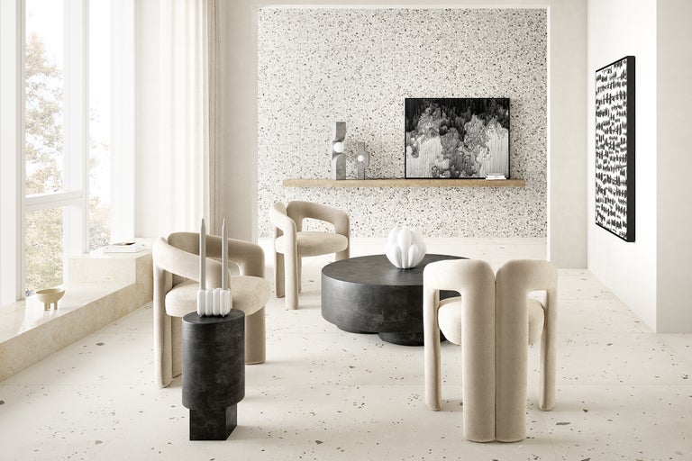 Heller Raum mit Terrazzoboden, Sitzgruppe und dekorativen Elementen