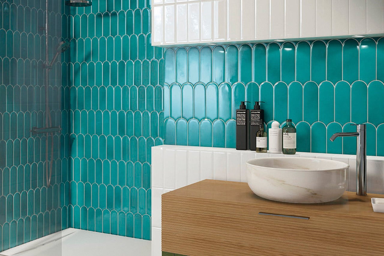 Badezimmer mit Dusche, Waschbecken und Wandfliesen in Fischgrätenmuster