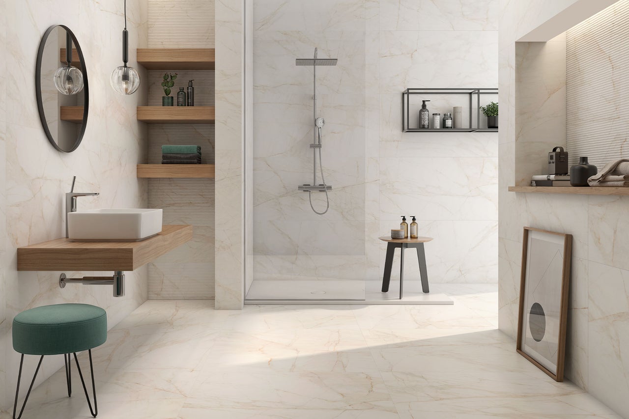 Modernes, helles Badezimmer mit Fliesen in Marmoroptik, begehbarer Dusche mit Glastrennwand, Holzregalen und Aufsatzwaschbecken.