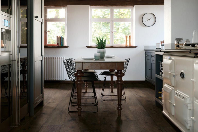 Helle Küche mit Esstisch, Stühlen, Fenstern und Küchengeräten