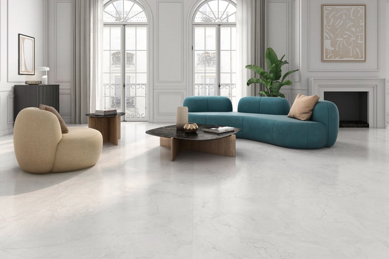 Heller Wohnraum mit Sessel, Sofa und Marmorbodenfliesen.