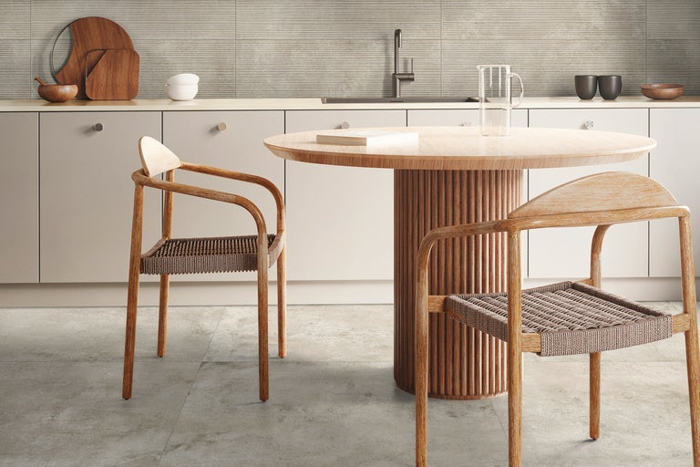 Helle Küche mit Esstisch und Stühlen aus Holz, Arbeitsplatte und gefliestem Fliesenspiegel