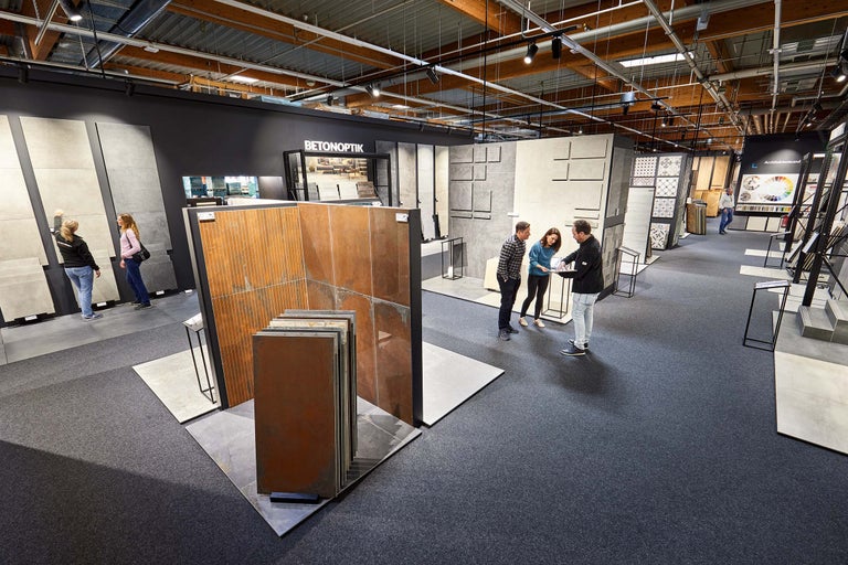 Fliesenausstellung im Hornbach Markt mit Kunden und verschiedenen Fliesendesigns.