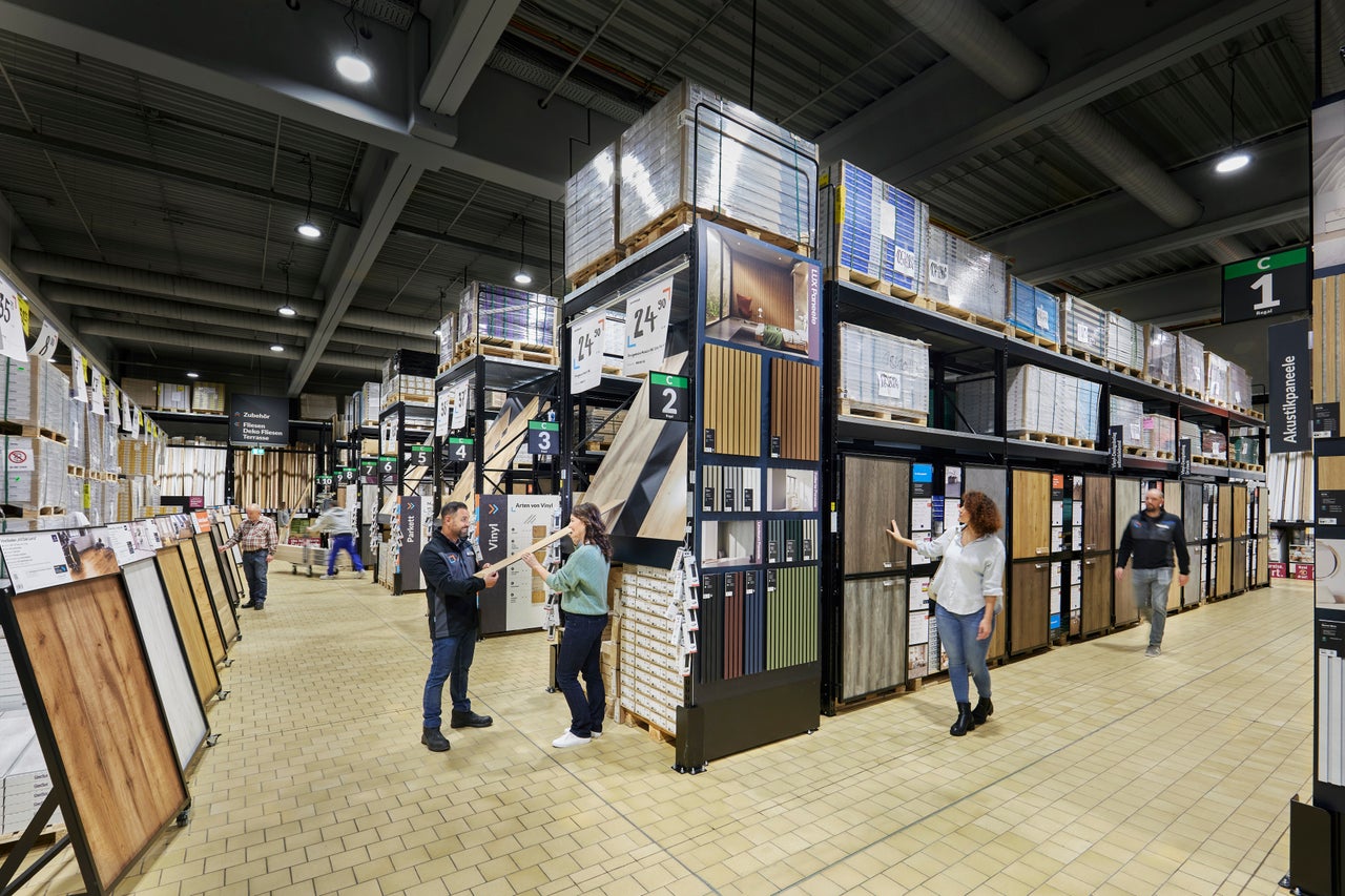 Gang im Hornbach Baumarkt mit Regalen voller Bodenbeläge wie Vinyl, Parkett und Paneele.
