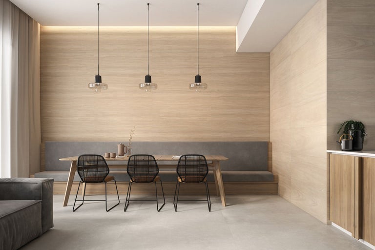 Helles Esszimmer mit Holzwand, Esstisch, Sitzbank und drei Pendelleuchten.