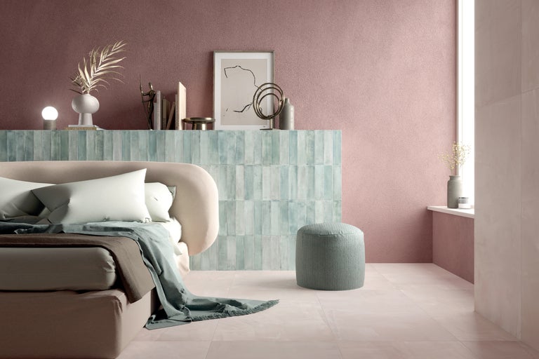 Helles Schlafzimmer mit Bett, Hocker und Wandfliesen