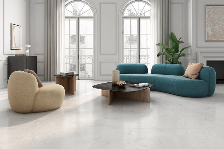 Helles Wohnzimmer mit blauer Couch, Sessel und Marmorboden