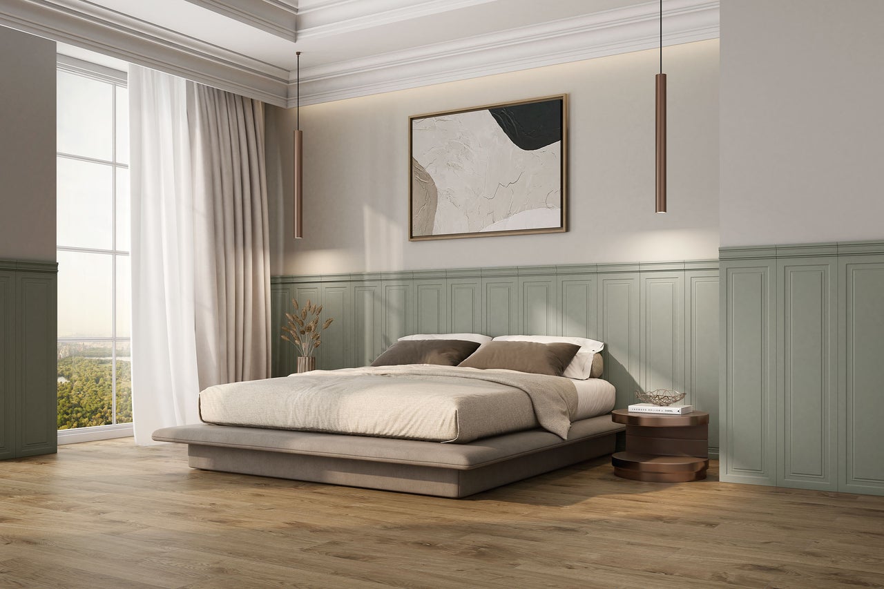Modernes Schlafzimmer mit grüner Wandtäfelung, hellem Holzboden und einem Polsterbett. Lange Pendelleuchten hängen über dem Nachttisch.