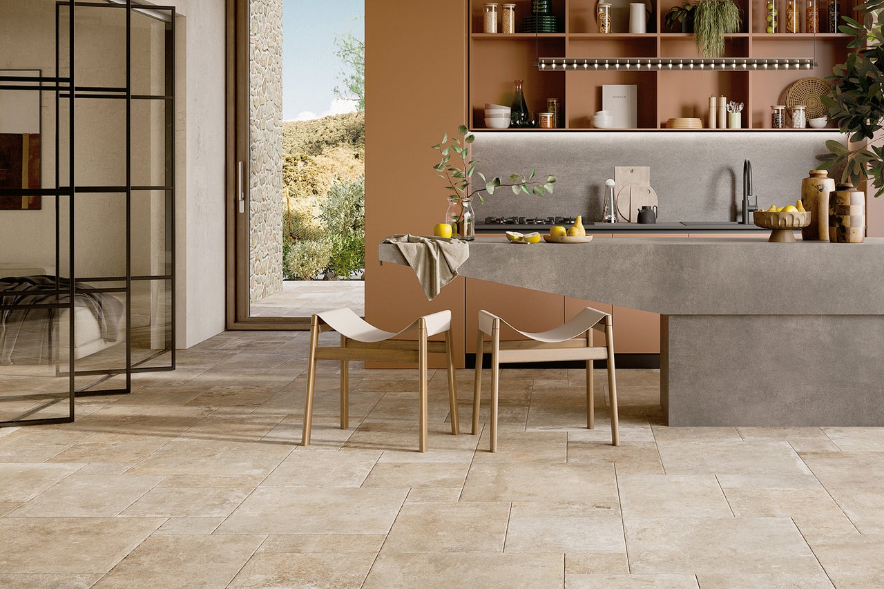 Helle, moderne Küche mit Steinfliesenboden, Kücheninsel und Holzhockern.