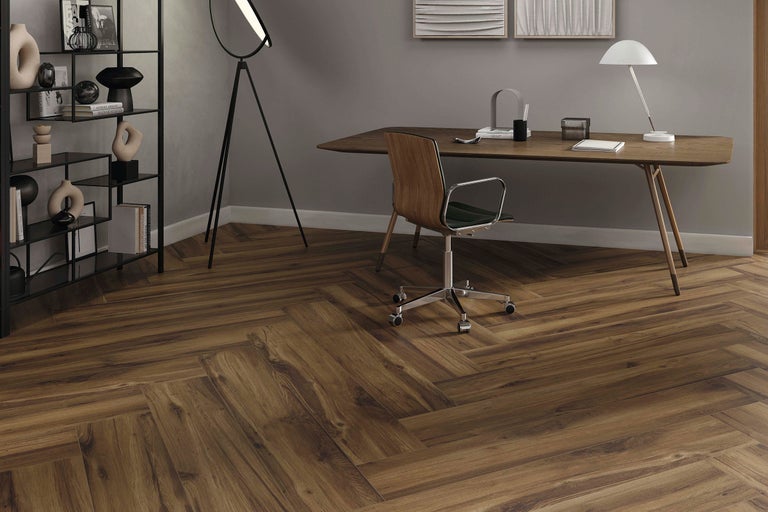 Büro mit Schreibtisch, Bücherregal und dunklem Holzboden im Fischgrätmuster