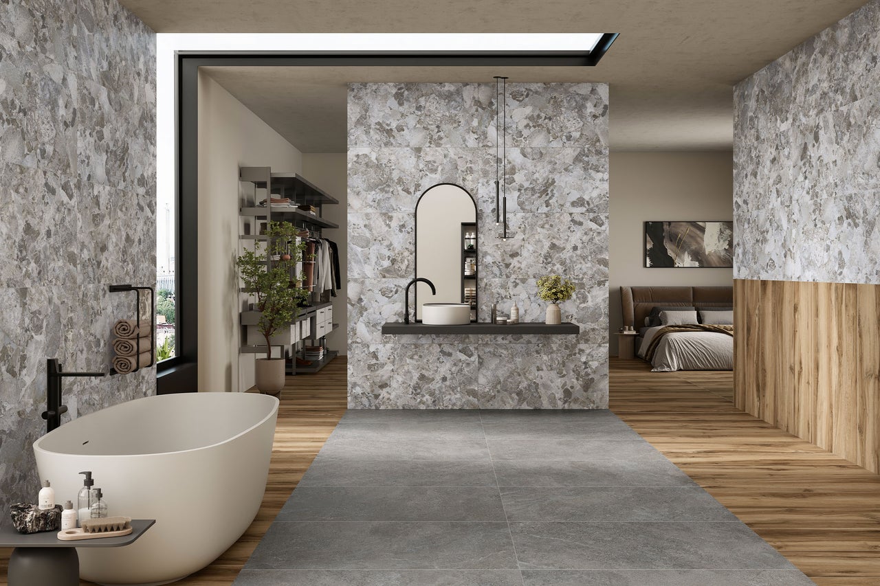 Modernes Badezimmer mit Badewanne, Waschtisch und Fliesen in Steinoptik