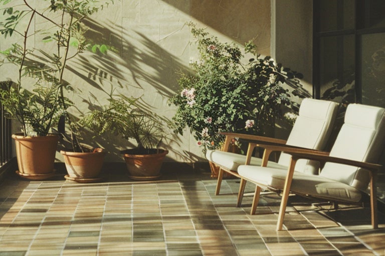 Helle Terrasse mit Topfpflanzen und zwei Sesseln