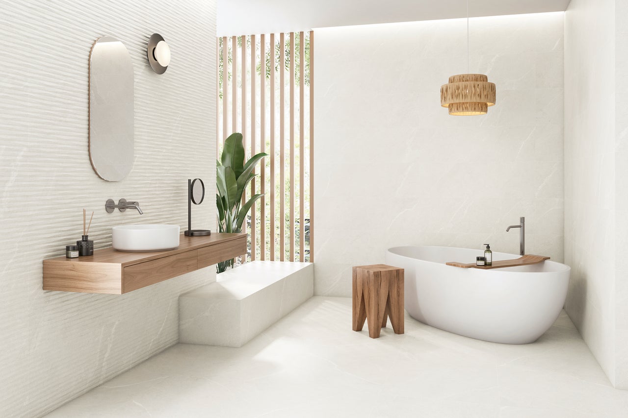 Helles Badezimmer mit Badewanne, Waschtisch und Holzdetails für eine freundliche Atmosphäre.