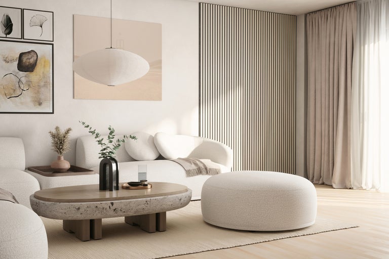 Wohnzimmer mit Sofa, Hocker, Tisch und dekorativen Elementen in einem hellen und freundlichen Design.