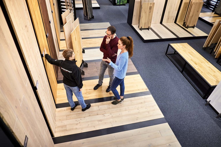 Kunden lassen sich Bodenbeläge im Hornbachmarkt zeigen